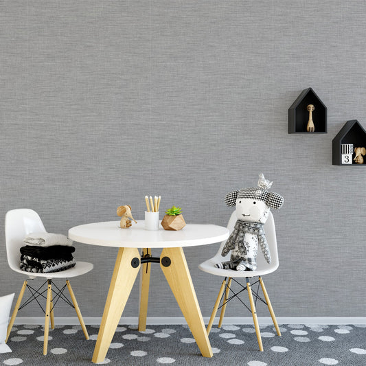 A children's table set with plush and wooden toys featuring a grey and silver wallpaper with a woven fabric effect pattern, creating a subtle textured appearance.