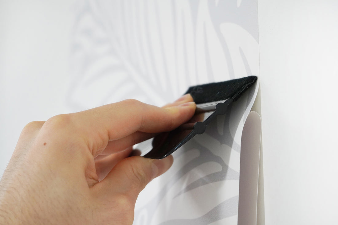 Squeegee being used on wallpaper to get rid of air bubbles