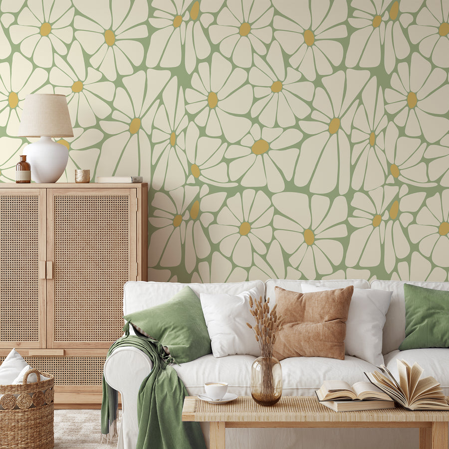 A living room furnished with neutral colours showing 'Amaryllis' which is a retro wallpaper featuring oversized yellow and cream daisy flowers with bold golden centres in a repeating 1970s-inspired floral pattern.