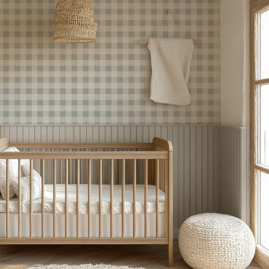 A baby's nursery with light coloured furniture with Fallon wallpaper which is a buffalo check wallpaper featuring a classic beige and cream gingham pattern with a subtle woven fabric effect.