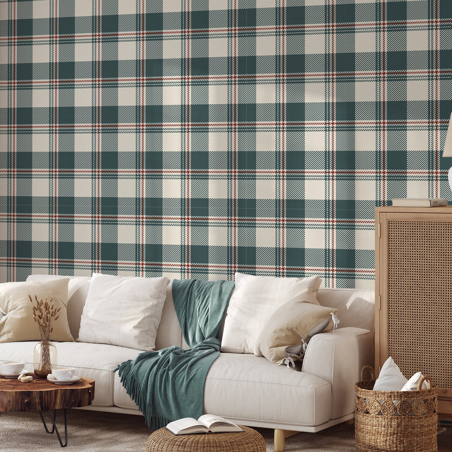 A living room with a cream sofa with cushions and a teal blanket across, a low coffee table with baskets and a rattan cupboard showing 'Brielle' which is a Neutral blue wallpaper featuring a buffalo check gingham plaid pattern with soft blue, cream and grey squares in a fabric-inspired repeating design.