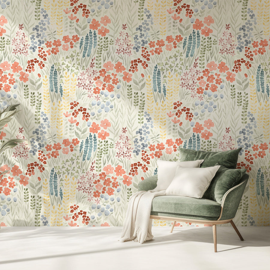 A living room with a corduroy olive green chair with cream pillows showing the Camellia wallpaper which has colourful watercolor wildflowers and green foliage in a soft repeating botanical pattern.