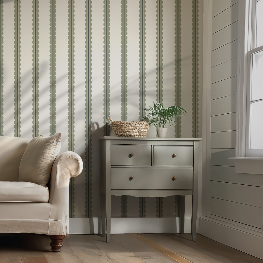 A living room with a beige sofa with a sage side drawer featuring the wallpaper Carter which is a scallop stripe with gentle curved stripe details in a soft neutral colour palette.