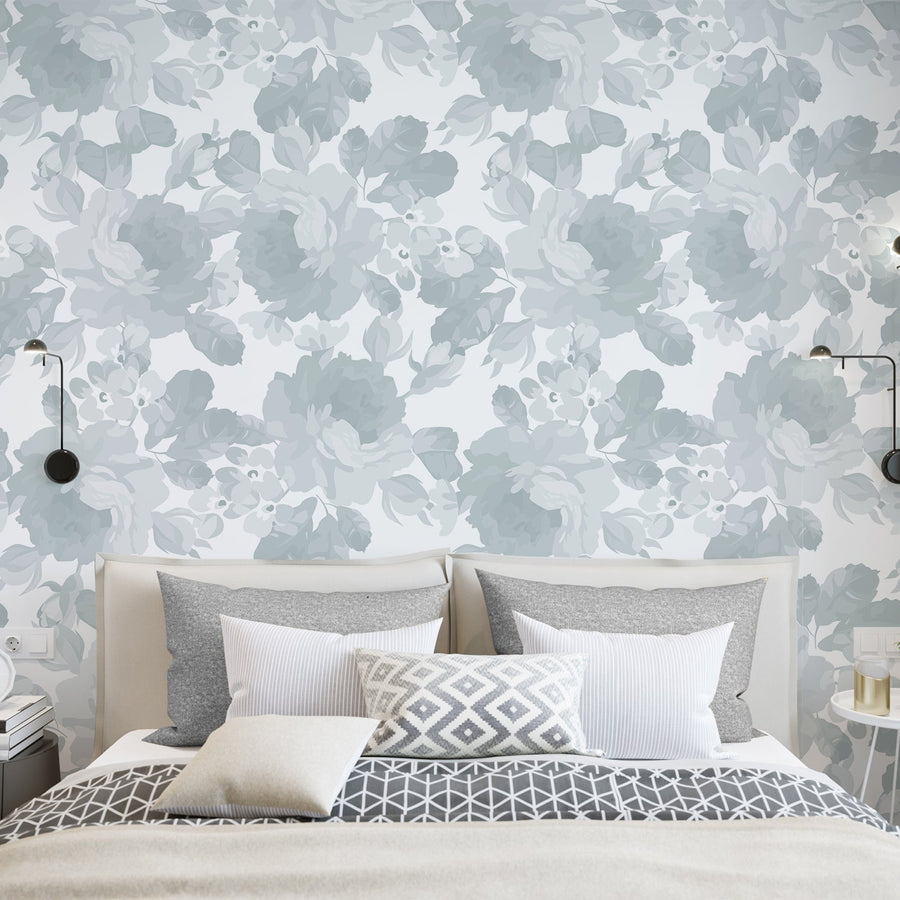 A bedroom with modern furnishings featuring the Selena wallpaper which is a grey wallpaper with an illustrated orchard of flowers with delicate botanical details in a soft repeating pattern on a white background.